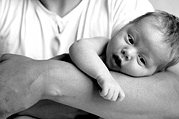 A new born baby in his father's arms, black and white image