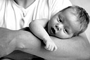 A baby in his father’s arms, black and white image