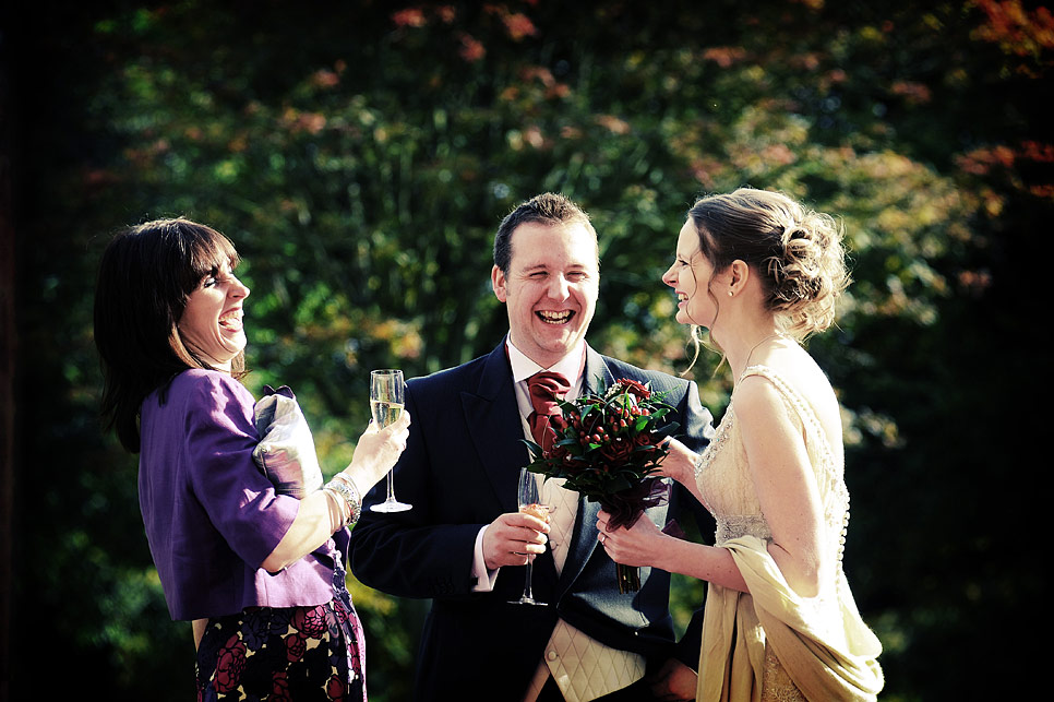 Bride and groom sharing a joke with the grooms sister